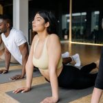 Group of adults practicing yoga cobra pose indoors for mindfulness and fitness.