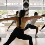 A diverse group practicing yoga poses in a well-lit indoor studio, focusing on balance and relaxation.